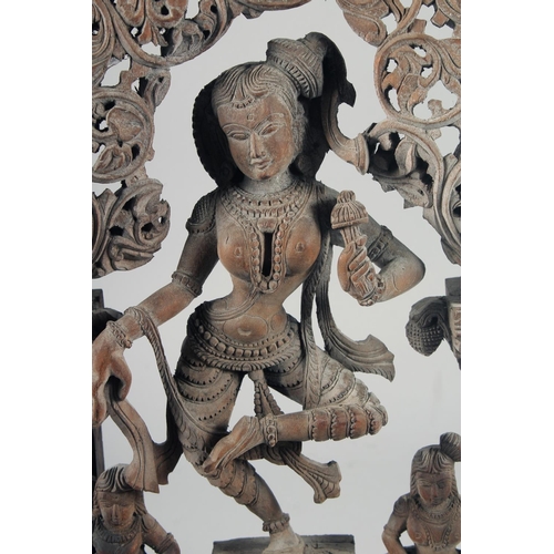 347 - A FINE 19TH-20TH CENTURY INDIAN CARVED WOODEN GROUP, depicting a central dancing figure, 49cm x 32cm... 