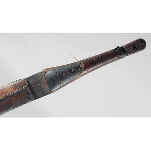 354 - A 19TH CENTURY OMANI KATTARA SWORD IN A LEATHER OVERLAID WOODEN SCABBARD, 100cm long.