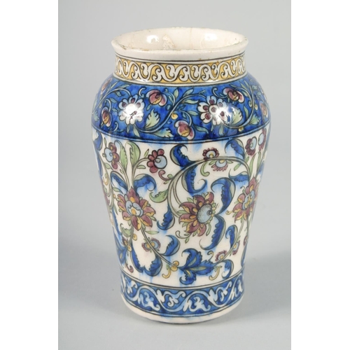 357 - A PERSIAN QAJAR GLAZED POTTERY VASE, painted with foliate motifs, 19cm high.