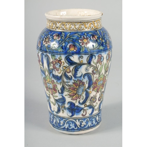 357 - A PERSIAN QAJAR GLAZED POTTERY VASE, painted with foliate motifs, 19cm high.