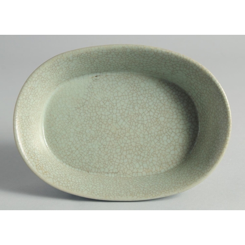 48 - A CHINESE CELADON CRACKLE GLAZE OVAL FORM BRUSH WASHER, raised on four feet, 20cm wide.