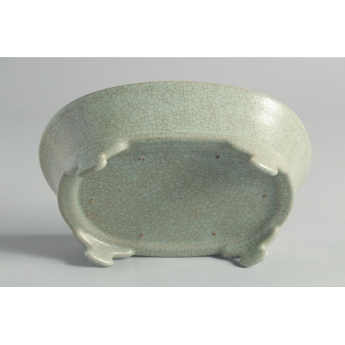 48 - A CHINESE CELADON CRACKLE GLAZE OVAL FORM BRUSH WASHER, raised on four feet, 20cm wide.