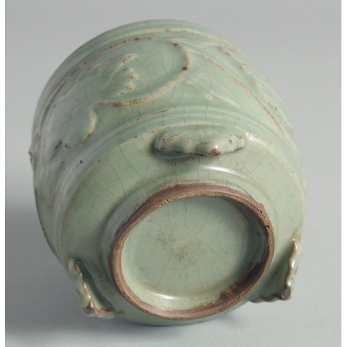 49 - A CHINESE CELADON GLAZE CENSER, relief-decorated with leaves and vine, raised on three feet, 10cm hi... 