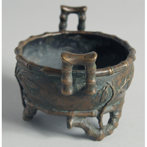 54 - A SMALL CHINESE BRONZE CENSER, with bamboo formed handles and feet, the base with Xuande mark, 12cm ... 