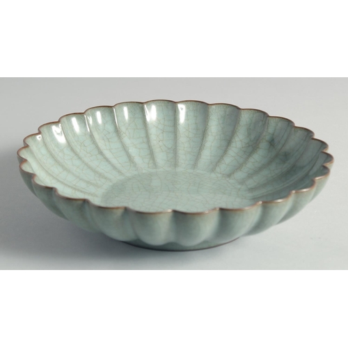 56 - A CHINESE CELADON CRACKLE GLAZE RIBBED CIRCULAR DISH, 24cm diameter.