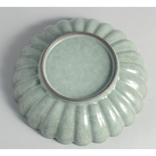 56 - A CHINESE CELADON CRACKLE GLAZE RIBBED CIRCULAR DISH, 24cm diameter.