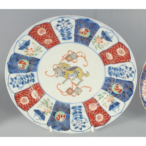 78 - THREE JAPANESE IMARI PORCELAIN PLATES, one painted with a central dog, the other two with flora, lar... 