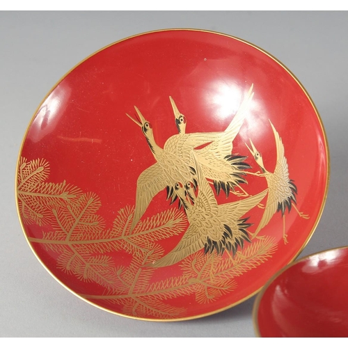 85 - A COLLECTION OF SEVEN JAPANESE RED LACQUER DISHES, four pieces with gilt decoration depicting cranes... 