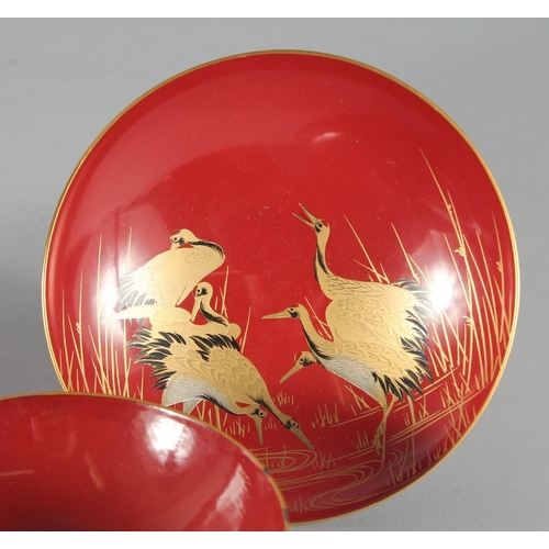 85 - A COLLECTION OF SEVEN JAPANESE RED LACQUER DISHES, four pieces with gilt decoration depicting cranes... 