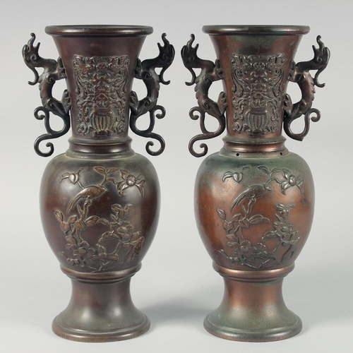 88 - A PAIR OF JAPANESE TWIN HANDLE BRONZE VASES, relief decorated with birds and native flora, 35.5cm hi... 