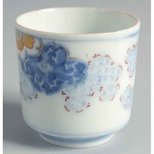 99 - A JAPANESE BLUE AND WHITE PORCELAIN CUP, decorated with foliate motifs and gilt highlights, 6.5cm hi... 