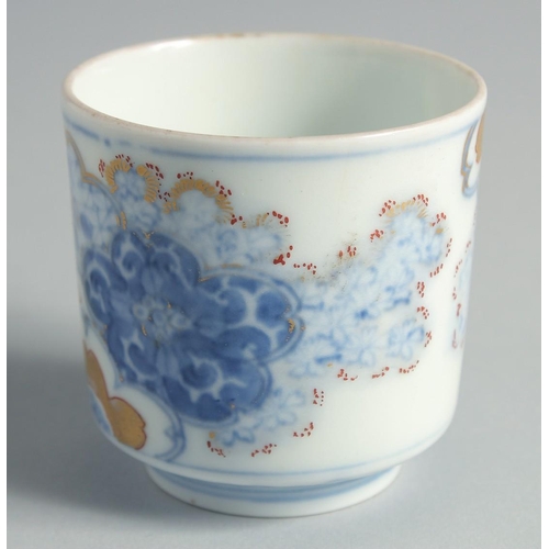 99 - A JAPANESE BLUE AND WHITE PORCELAIN CUP, decorated with foliate motifs and gilt highlights, 6.5cm hi... 