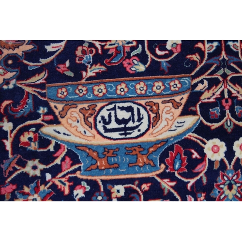 1014 - AN UNUSUAL PERSIAN CARPET, rich ground and deep red border, all with Persian and Islamic bowls, vase... 