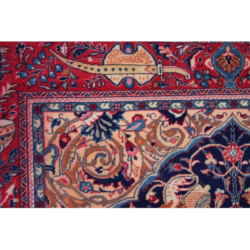 1014 - AN UNUSUAL PERSIAN CARPET, rich ground and deep red border, all with Persian and Islamic bowls, vase... 