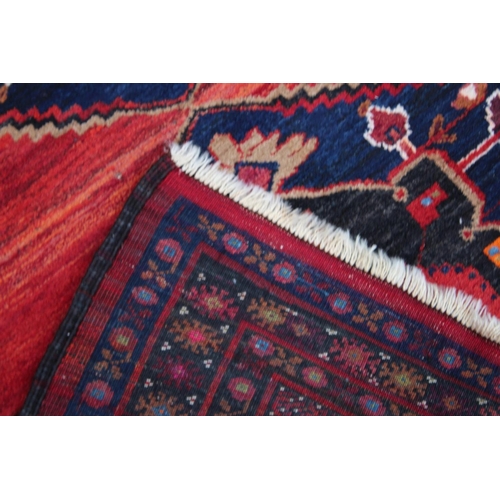 1015 - A GOOD SMALL PERSIAN CARPET, red ground with two large central medallions. 7'2