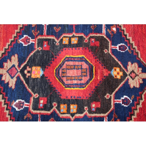 1015 - A GOOD SMALL PERSIAN CARPET, red ground with two large central medallions. 7'2