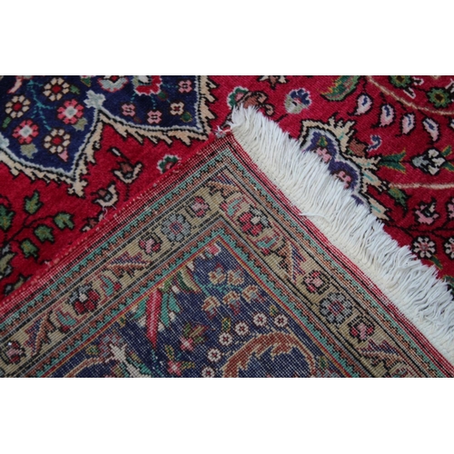 1019 - A GOOD LARGE PERSIAN CARPET, crimson ground with floral decoration in a similar blue ground border. ... 