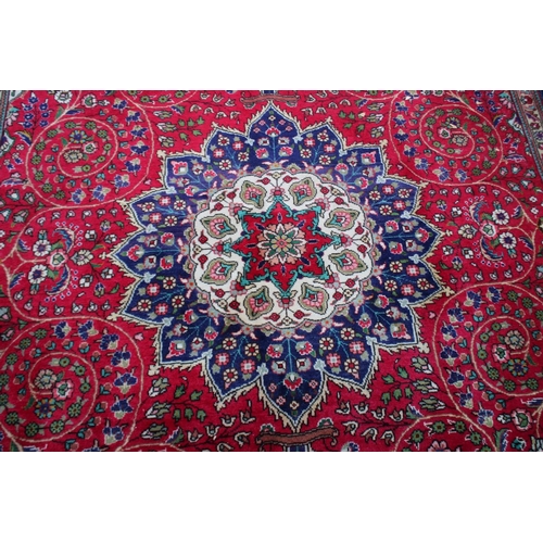 1019 - A GOOD LARGE PERSIAN CARPET, crimson ground with floral decoration in a similar blue ground border. ... 