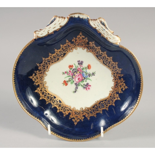 1085 - AN 18TH CENTURY WORCESTER WET BLUE SHELL SHAPED DISH painted with flowers under and elaborate gilt b... 