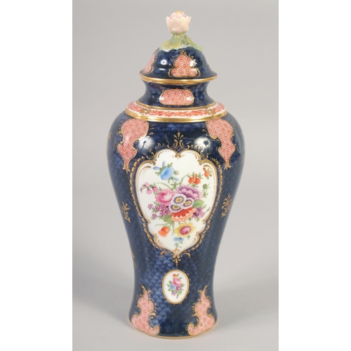 1090 - A ROYAL WORCESTER VASE AND COVER painted with flowers on a blue scale ground with red cell panels by... 