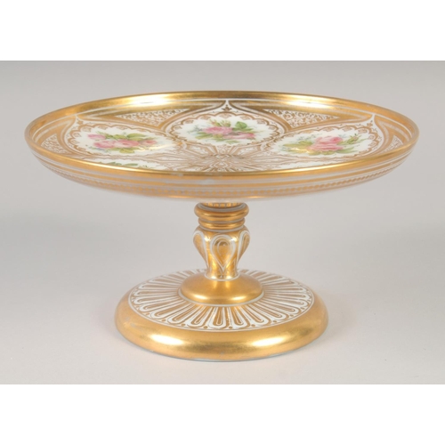 1107 - A 19TH CENTURY WHITE GLASS COMPORT painted with flowers and gilded.