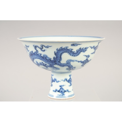 1137 - A CHINESE BLUE AND WHITE PORCELAIN STEM CUP with dragon and phoenix. 15.5cm diameter.