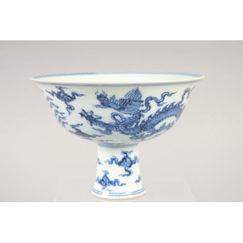 1137 - A CHINESE BLUE AND WHITE PORCELAIN STEM CUP with dragon and phoenix. 15.5cm diameter.