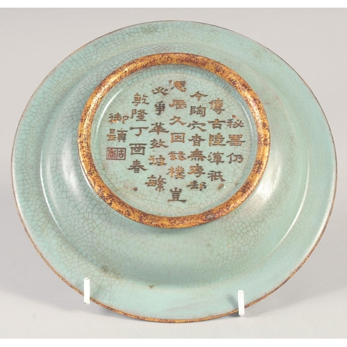 1138 - A CHINESE CELADON PETAL FORM DISH with incised gilt characters to the base. 20cm diameter.