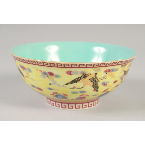 1144 - A CHINESE YELLOW GROUND FAMILLE ROSE BOWL decorated with cranes, six character mark to base. 15cm di... 