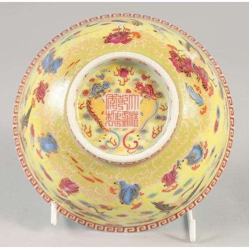 1144 - A CHINESE YELLOW GROUND FAMILLE ROSE BOWL decorated with cranes, six character mark to base. 15cm di... 