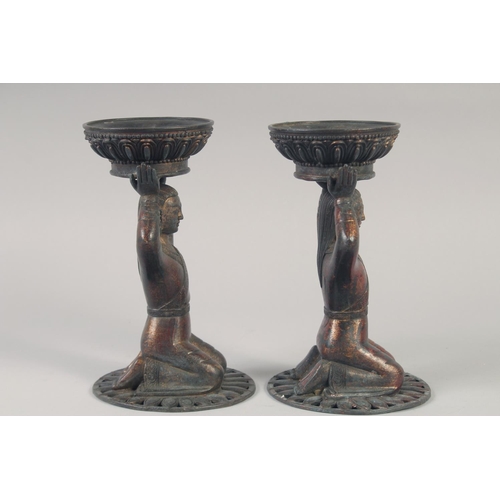 1147 - A PAIR OF TIBETAN GILT BRONZE CANDLESTICKS. 23cm high.