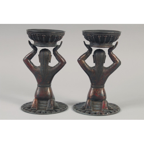 1147 - A PAIR OF TIBETAN GILT BRONZE CANDLESTICKS. 23cm high.