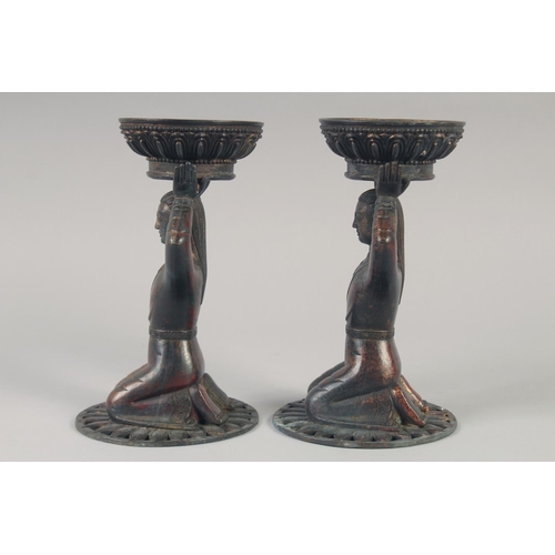 1147 - A PAIR OF TIBETAN GILT BRONZE CANDLESTICKS. 23cm high.