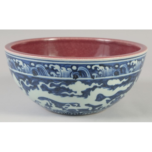 1154 - A CHINESE BLUE, WHITE AND COPPER RED BOWL decorated with dragons, six character mark to base. 27.5cm... 