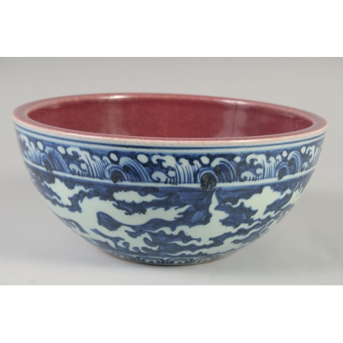 1154 - A CHINESE BLUE, WHITE AND COPPER RED BOWL decorated with dragons, six character mark to base. 27.5cm... 