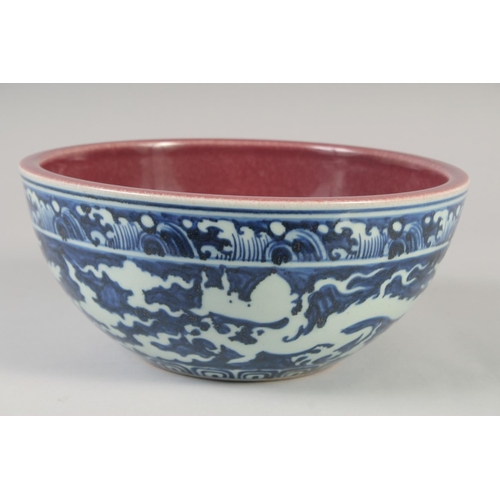 1154 - A CHINESE BLUE, WHITE AND COPPER RED BOWL decorated with dragons, six character mark to base. 27.5cm... 