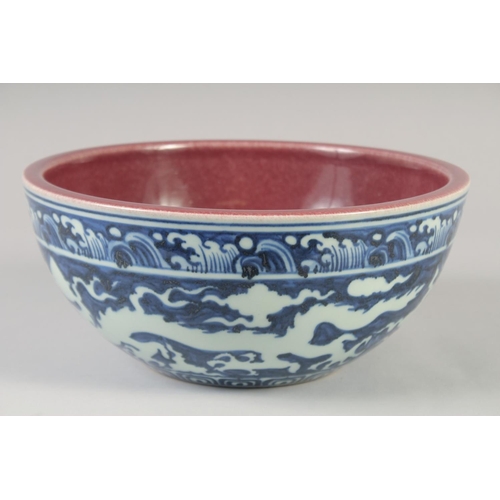 1154 - A CHINESE BLUE, WHITE AND COPPER RED BOWL decorated with dragons, six character mark to base. 27.5cm... 