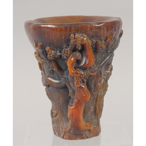 1157 - A GOOD CHINESE CARVED HORN LIBATION CUP carved with lotus and figures. 5.5ins.