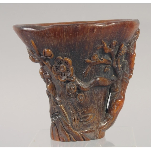 1157 - A GOOD CHINESE CARVED HORN LIBATION CUP carved with lotus and figures. 5.5ins.