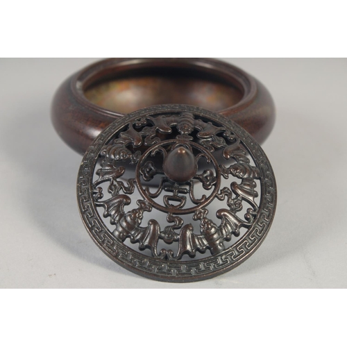 1174 - A CHINESE CIRCULAR BRONZE GOLD SPLASH CENSER AND COVER. 3.75ins diameter.