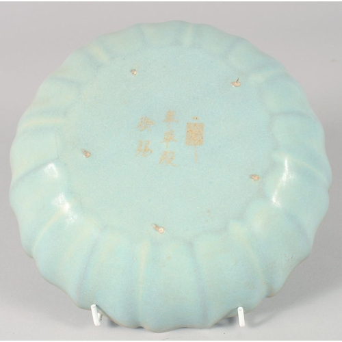 1187 - A CHINESE CELADON PETAL FORM BOWL, with carved characters, 22cm diameter.