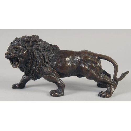 1215 - A BRONZE STANDING LION. 11ins long.