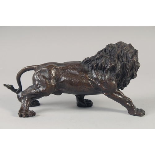 1215 - A BRONZE STANDING LION. 11ins long.