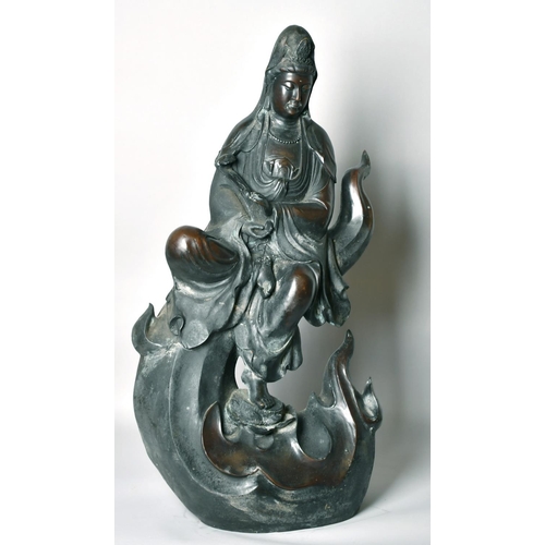 1221 - A LARGE CHINESE BRONZE FIGURE OF GUANVIN sitting atop a wave, holding a sceptre, bearing a six-chara... 