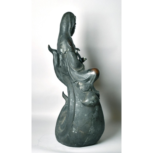 1221 - A LARGE CHINESE BRONZE FIGURE OF GUANVIN sitting atop a wave, holding a sceptre, bearing a six-chara... 