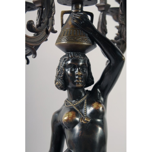 1233 - A VERY GOOD PAIR OF BRONZE AND GILDED BRONZE NUBIAN FIGURE FIVE-LIGHT CANDELABRA, each with four scr... 