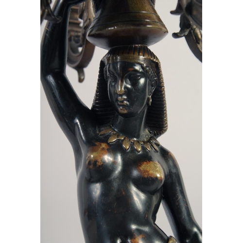 1233 - A VERY GOOD PAIR OF BRONZE AND GILDED BRONZE NUBIAN FIGURE FIVE-LIGHT CANDELABRA, each with four scr... 