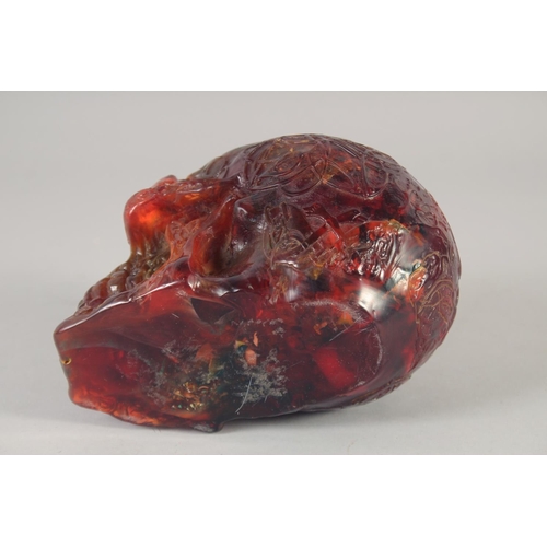 1247 - A CARVED AMBER STYLE SKULL.