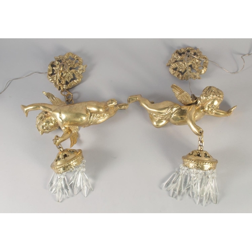 1277 - A GOOD PAIR OF GILT BRONZE CUPID WALL LIGHTS with cut glass prism drop. 12ins long.