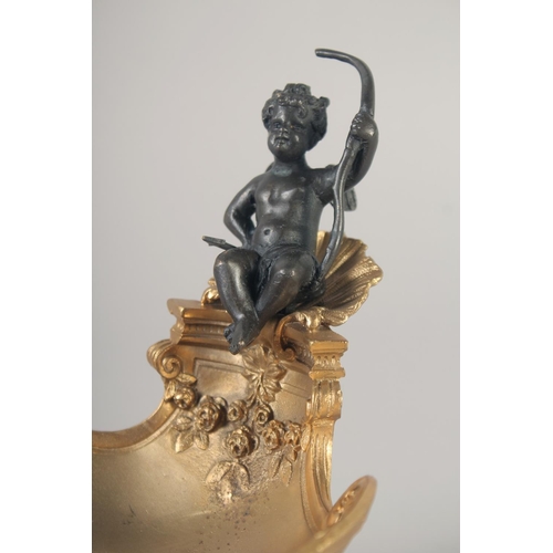 1283 - A GILT BRONZE AND BRONZE SALT with a cherub. 6.5ins.